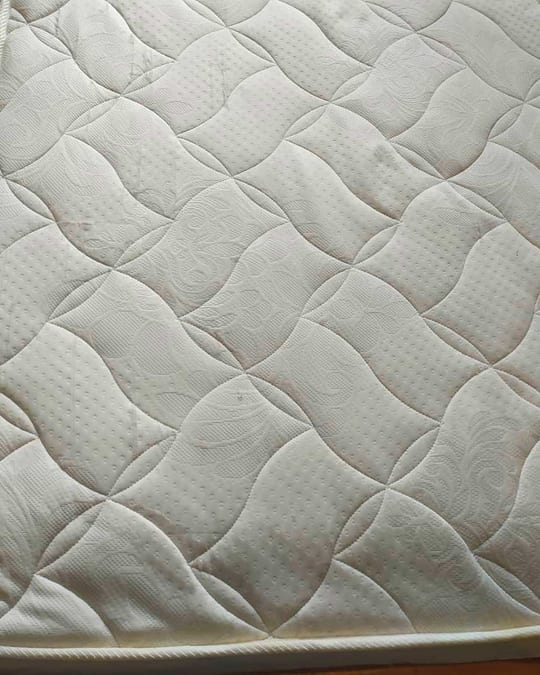 Matelas capitonné — taches jaunes à gauche, blanc net à droite après nettoyage